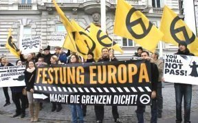 Far-right activists at an Identitarian Movement of Austria anti-immigration rally in Vienna. The German-language signs read "Fortress Europe", "Close the Borders Now!", "My Home is Not an Immigrant Country", and "Europe, Youth, Reconquista".