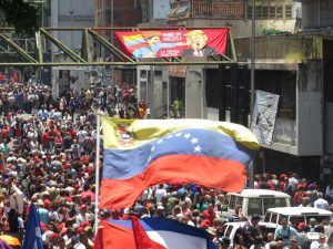 A "Hands Off Venezuela" banner flies above a crowd at a pro-Maduro rally in Caracas, Venezuela.