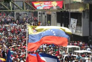A "Hands Off Venezuela" banner flies above a crowd at a pro-Maduro rally in Caracas, Venezuela.