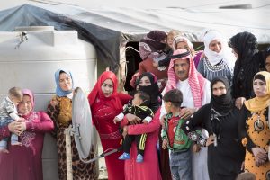 Residents at a Syrian refugee camp in the Beqaa Valley of eastern Lebanon prepare to greet Secretary-General Ban Ki-moon during his visit there in March of 2016. (Photo: UN Photo/Mark Garten 0)