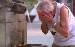 A man attempts to cool off at a water fountain as a heat wave strikes Europe. (Photo: YouTube screenshot)