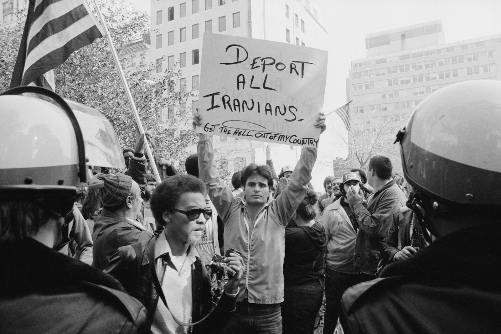 A man is raising a sign that reads "deport all Iranians, get the hell out of my country"during a 1979 Washington, DC, student protest of the Iran hostage crisis.