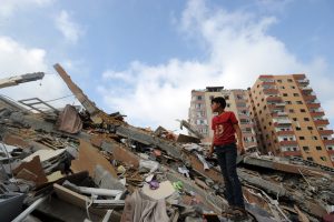 Palestinians collect their belongings from under the rubble of a residential tower, which witnesses said was destroyed in an Israeli air strike in Gaza City on August 24, 2014.