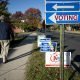 A voter walks past candidate signs on election day 2014.