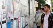 A Tunisian voter peruses one of the many officially designated walls where parties were permitted to present their campaign posters during Tunisia's 2011 election. More than 65 parties and independent lists competed for seats in the constituent assembly