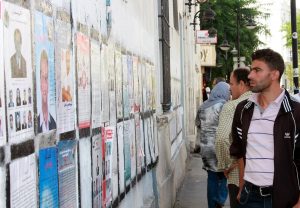 A Tunisian voter peruses one of the many officially designated walls where parties were permitted to present their campaign posters during Tunisia's 2011 election. More than 65 parties and independent lists competed for seats in the constituent assembly