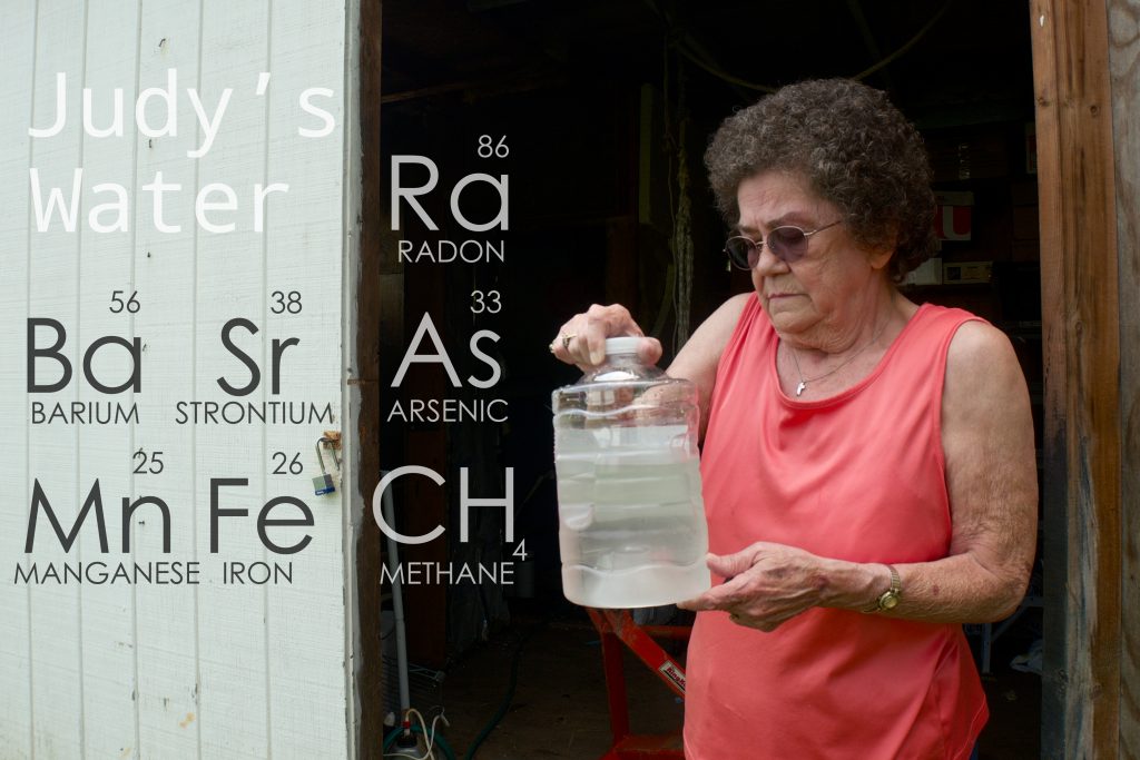 Pennsylvania resident Judy Eckert holding water contaminated with arsenic drawn from her private well. In 2007, Guardian Exploration drilled and fracked a Marcellus well 450 feet from her home, which she believes is part of the cause of her contaminated her water supply. In 2010, the Pennsylvania Department of Environmental Protection found a waste pit buried illegally into her season high water table.