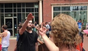 A counter-protester gives a white supremacist the middle finger. The white supremacists responds with a Nazi salute. Charlottesville August 12, 2017.