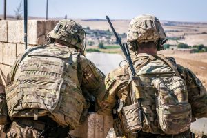 Two U.S. Soldiers keep an eye on the demarcation line during a security patrol outside Manbij, Syria, June 26, 2018.