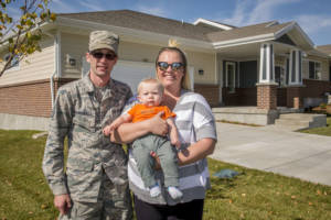 Staff Sgt. Austin Marshall, 84th Radar Evaluation Squadron, his spouse Heather, and 8-month-old son Law pose for a photo in front of their new base housing unit at Hill Air Force Base, Utah, Oct. 11, 2017.