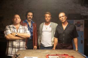 (L-R) Louis Lombardi as Pauly Callahan, Rhys Coio as Ray Darrow, Travis Fimmel as Harry Barber, and William Fichtner as Enzo Rotella in the Momentum Pictures’ action, crime, comedy “FINDING STEVE MCQUEEN”. Photo courtesy of Momentum Pictures