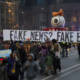 Protesters hold sign saying "fake news? fake economy! during January 2017 protest of Donald Trump inauguration.