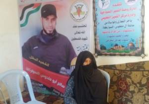 Rasmi and Mohammad al-Swarka's mother Om Rasmi in front of a portrait of Mohammad.