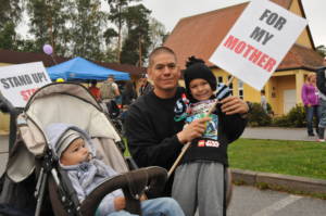 U.S. Army Sgt. 1st. Class Robert Ybarra with the Non-Commissioned Officer Academy poses with his son Aiden for a photo before walking a mile in red high-heels to promote the fight against violence towards women Sept. 22, 2012 at Rose Barracks. The event was hosted by Army Community Service. (U.S. Army Photo by Spc. Joshua Edwards/released) (Photo Credit: Spc. Joshua Edwards)