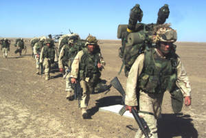 A US Marine with the 15th Marine Expeditionary Unit leads others to a security position after seizing a Taliban forward-operating base November 25, 2001