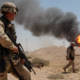 U.S. Army Sgt. Mark Phiffer stands guard duty near a burning oil well in the Rumaylah Oil Fields in Southern Iraq.