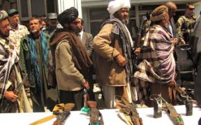 Former Taliban fighters return arms